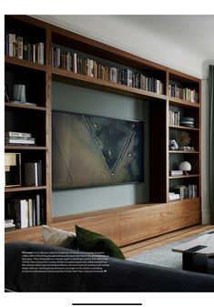 a living room filled with furniture and bookshelves next to a flat screen tv