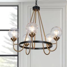 a chandelier with five clear globes hanging from it's metal frame