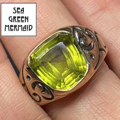 "Welcome to Sea Green Mermaid! For sale is a 10k yellow gold peridot ring. This antique ring is splendid! The natural peridot has a wonderful and unusual trapezoid shape with beautiful facets. The peridot has the classic luminous lime green glow, with lovely translucence. This large gemstone is securely bezel-set. The signet style ring is deeply carved with scrolling designs. This bewitching ring will energize and enchant you whenever you chose to wear it! The item shows normal wear for a pre-ow Green Citrine Rings With Accent Stones, Green Citrine Gemstone Rings, Green Citrine Jewelry For Anniversary, Anniversary Green Signet Ring With Bezel Setting, Gold Peridot Birthstone Ring With Accent Stones, Vintage Peridot Ring For May Birthstone, Oval Green Citrine Rings, Yellow Peridot Jewelry For May Birthstone, Yellow May Birthstone Jewelry