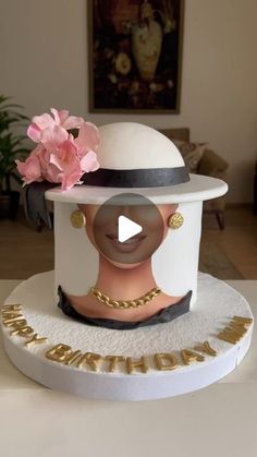 a cake with a woman's face on top and flowers in the middle, sitting on a table