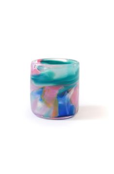 a colorful glass vase sitting on top of a white table