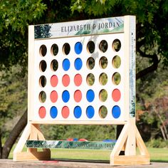 a giant four - in - a - row board game sits on a park bench