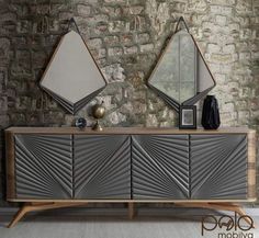 two mirrors are hanging on the wall above a sideboard with an art deco design