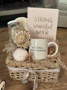 a coffee mug sitting on top of a wooden table next to a sign that says strong beautiful brave courageous