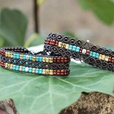 two bracelets sitting on top of a leaf