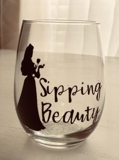 a wine glass with the words spring beauty painted on it, sitting on a table