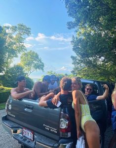 a group of people sitting in the back of a pick up truck