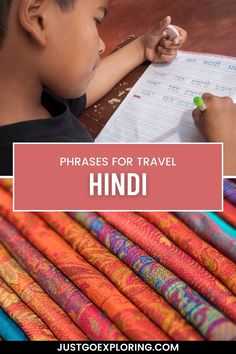 a young boy writing on a piece of paper with the words, phrases for travel hind