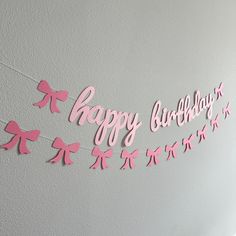 a pink happy birthday banner hanging on the wall