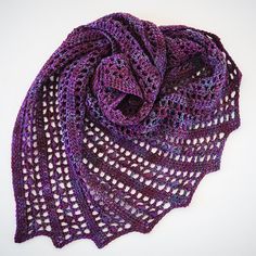 a purple crocheted shawl on a white surface