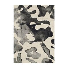 a rug with black and white paint splattered on it's surface, in the shape of an animal print