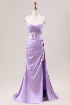 a purple dress on display in front of a mannequin