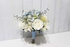 a bouquet of white and blue flowers on a table