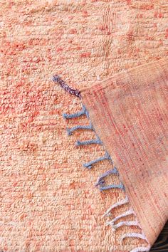 an orange and blue rug with fringes on it