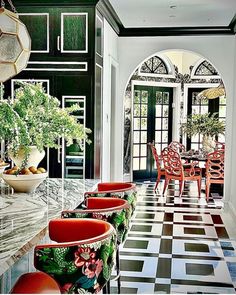 the dining room is decorated in black and white checkerboard flooring with red chairs