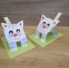 two paper cats sitting on top of each other