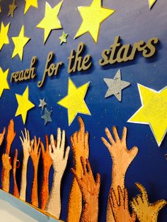 children's hands reaching for the stars on a bulletin board that says reach for the stars