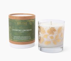 a candle that is sitting next to a container with the label country orchard on it