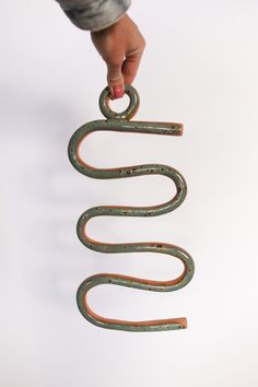 a person holding an old metal object in the air with it's hands and fingers