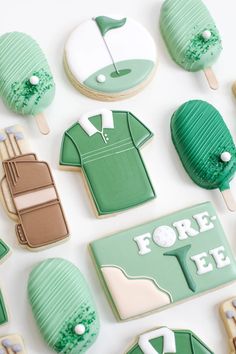 decorated cookies are arranged in the shape of golf shirts and tees, with green icing on them