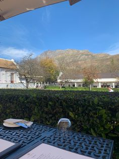 the table is set for two outside with mountains in the backgroung behind it