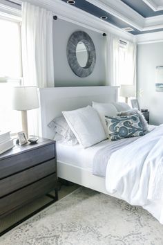 a white bed sitting in a bedroom next to a window