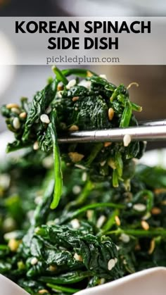 a white bowl filled with spinach and topped with sesame seeds