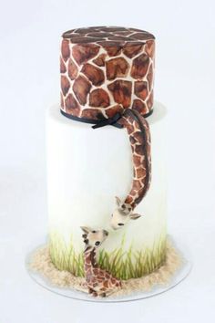 two giraffes are standing on top of a cake