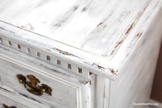 an old white painted dresser with gold handles