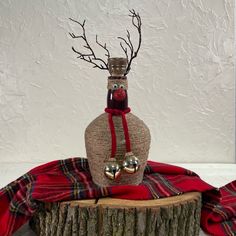 a bottle with a reindeer head on it sitting on top of a tree stump