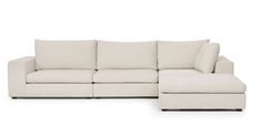 a white sectional couch with pillows on it's back and the seat folded out