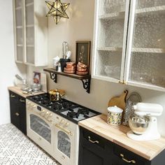 a kitchen with black and white cabinets, an oven and countertop area in the center