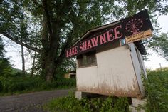 an old outhouse with a sign that says lake shawe on the front and side