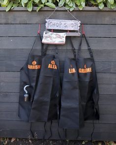 three black aprons hanging on a wall next to a sign that says chop shop