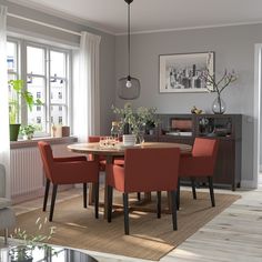 a dining room table with four chairs and a rug on the floor in front of it