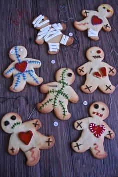 several decorated cookies are arranged on a wooden table with white string and red heart decorations