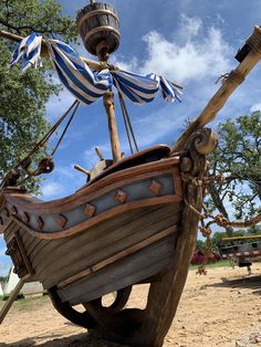 an old wooden pirate ship with blue and white striped sails