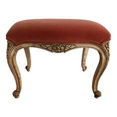 an ornate bench with red upholstered seat