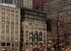 a city street filled with lots of tall buildings next to each other and traffic lights