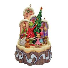 a figurine is shown on top of a christmas tree with people around it