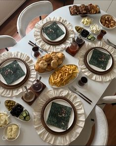 a white table topped with plates filled with food