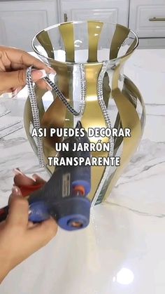 a person is using scissors to cut ribbon on a vase with the words asi puedes decorar un jaron transparente