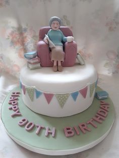 a birthday cake with a woman sitting in a chair