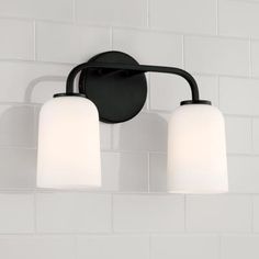 two light bathroom fixture in black finish with white glass shades on the top and bottom