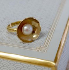 If a picture is worth a thousand words, then this elegant  Big Flower gold plated ring with a classic pink pearl says much more than a thousand words about its wearer. All eyes will be drawn to your gold plated ring, available in US sizes 5,6, 7 and 8 Can be Ordered with a white pearl ,black or a pink pearl (as seen in picture).Or can be made to order in any size. Please note your desired size in the message to seller area at checkout. This ring comes in a beautiful gift box. Each ring is made t Elegant Ring For Anniversary Gift, Gold Pearl Drop Ring For Anniversary, Gold Pearl Rings As A Gift, Gold Pearl Drop Rings As A Gift, Gold Rings With Pearl Drop For Gift, Heirloom Pearl Open Ring As Gift, Gold Pearl Drop Rings For Gifts, Classic Gold Rings For Anniversary Gift, Hallmarked Open Pearl Ring As Gift