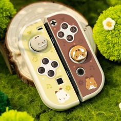 two game controllers sitting on top of green grass