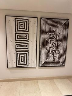 two black and white paintings hanging on the wall