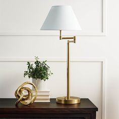 a lamp on top of a table next to a potted plant