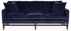 a blue velvet couch with two pillows on it's arms and legs, against a white background