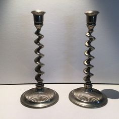 two silver candlesticks sitting next to each other